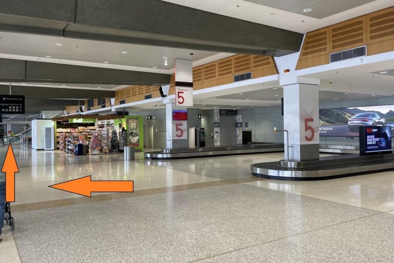 Descend the Escalators, collect your luggage as necessary and head towards Carousel #5 then continue walking past the convenience store